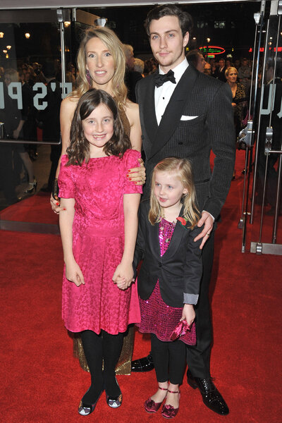Aaron Taylor Johnson with his wife and step daughters on a red carpet