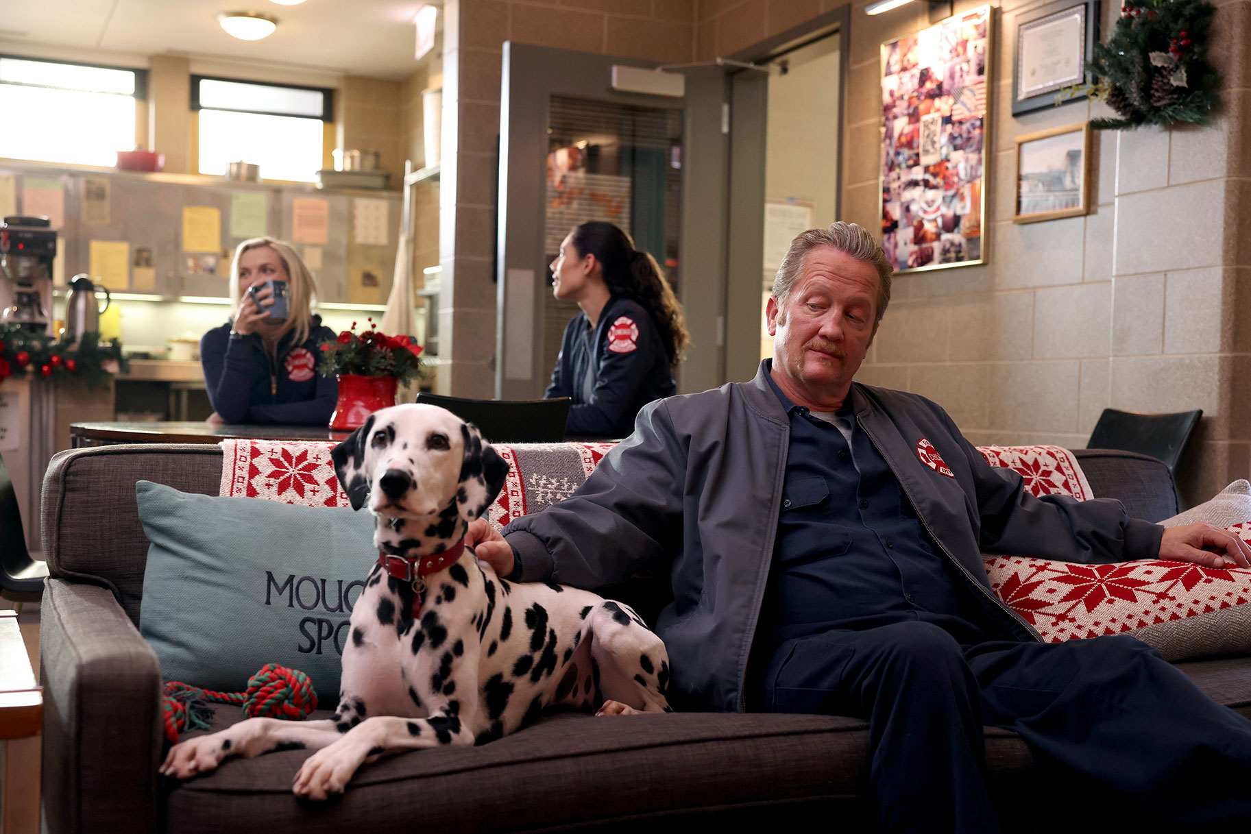 Tuesday the dalmatian sits on the firehouse couch with Mouch