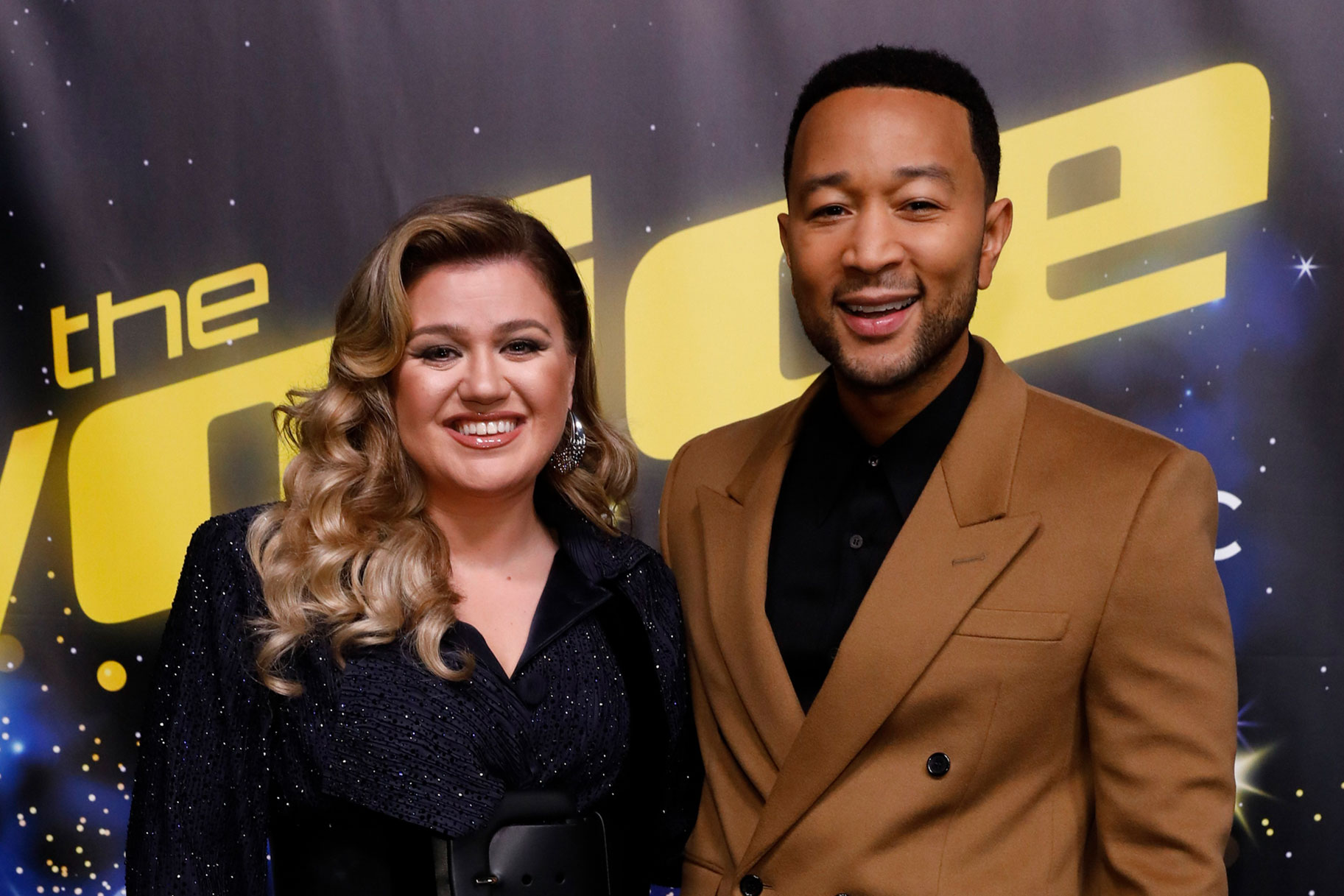 Kelly Clarkson and John Legend posing and smiling together