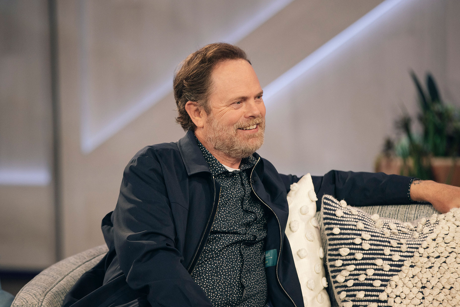 Rainn Wilson sitting on the couch of the Kelly Clarkson Show