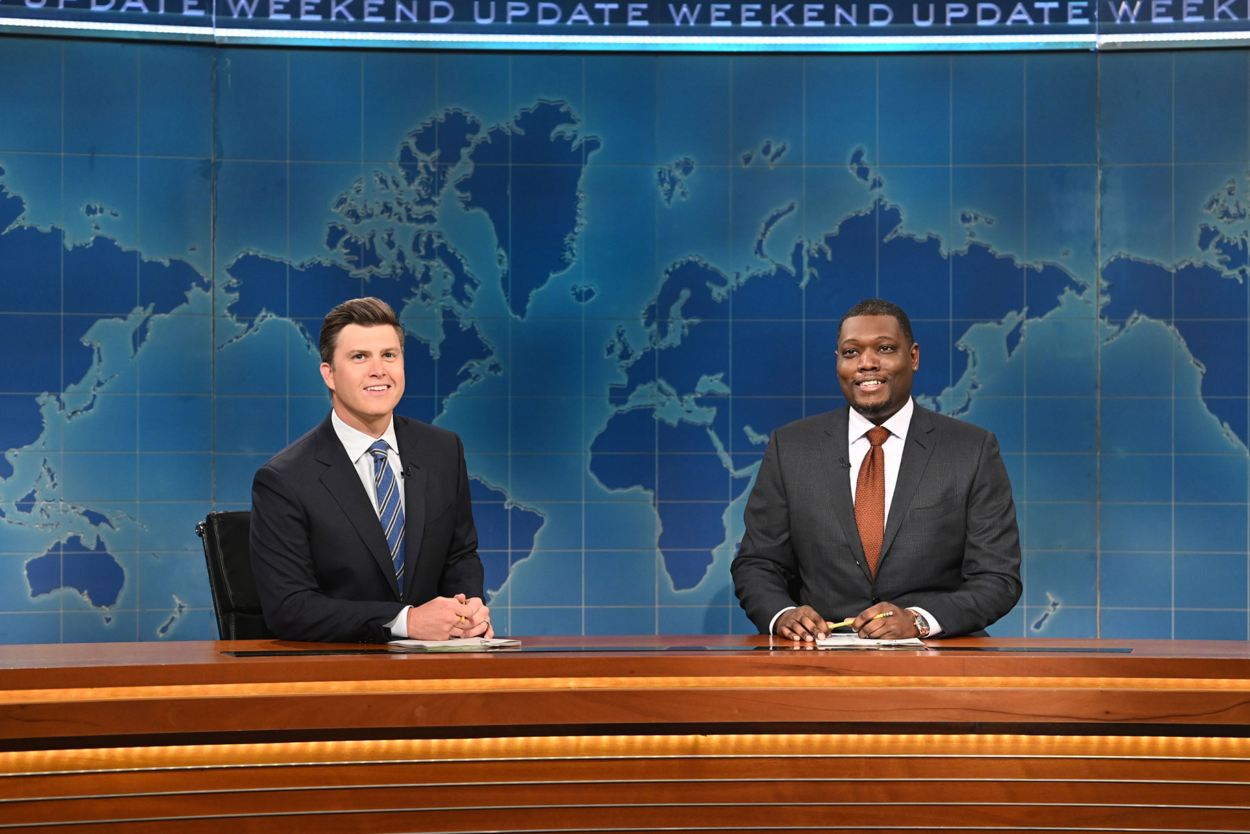 Colin Jost and Michael Che sitting at the 'Weekend Update' desk