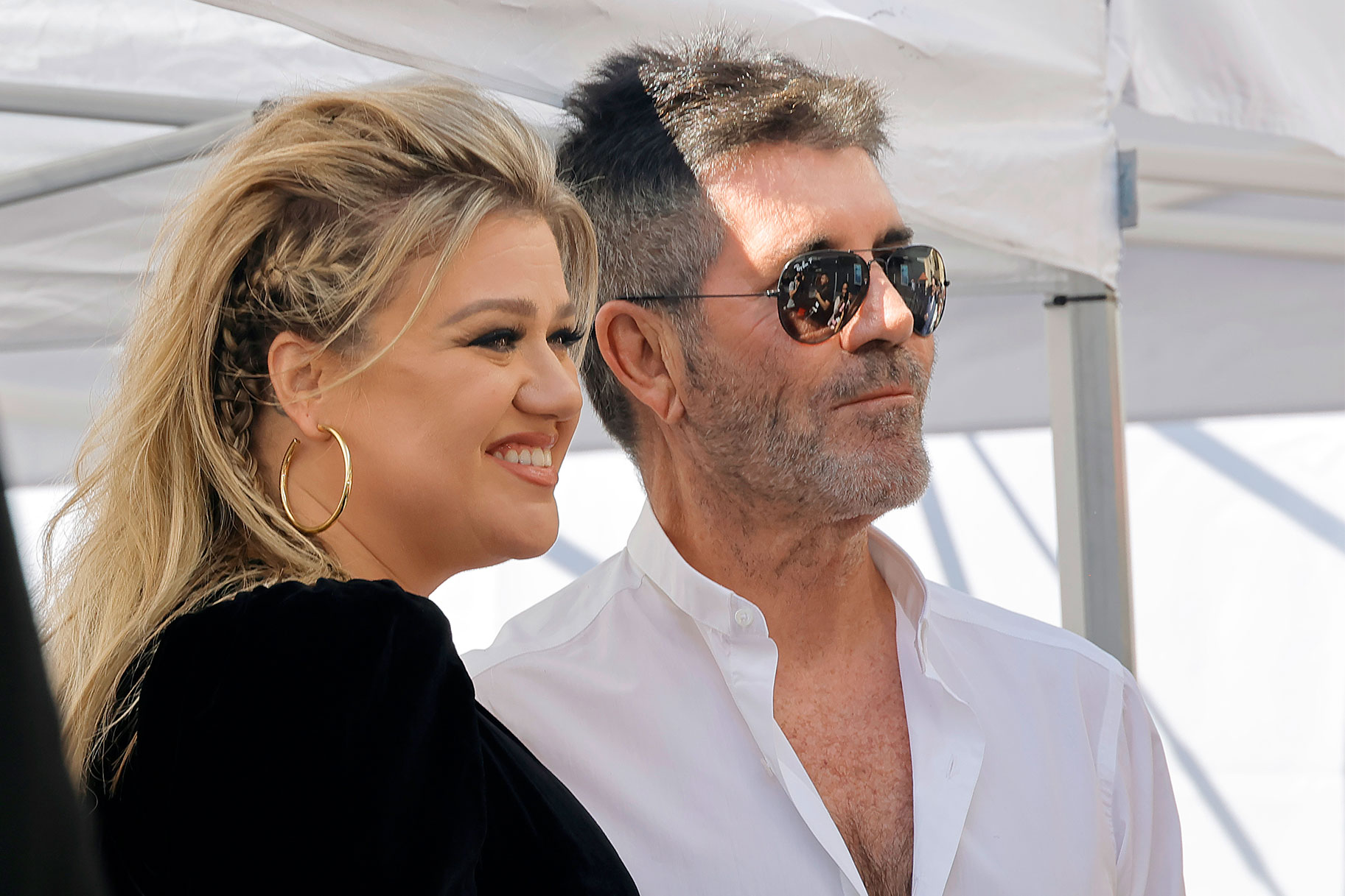 Kelly Clarkson posed and smiling with Simon Cowell