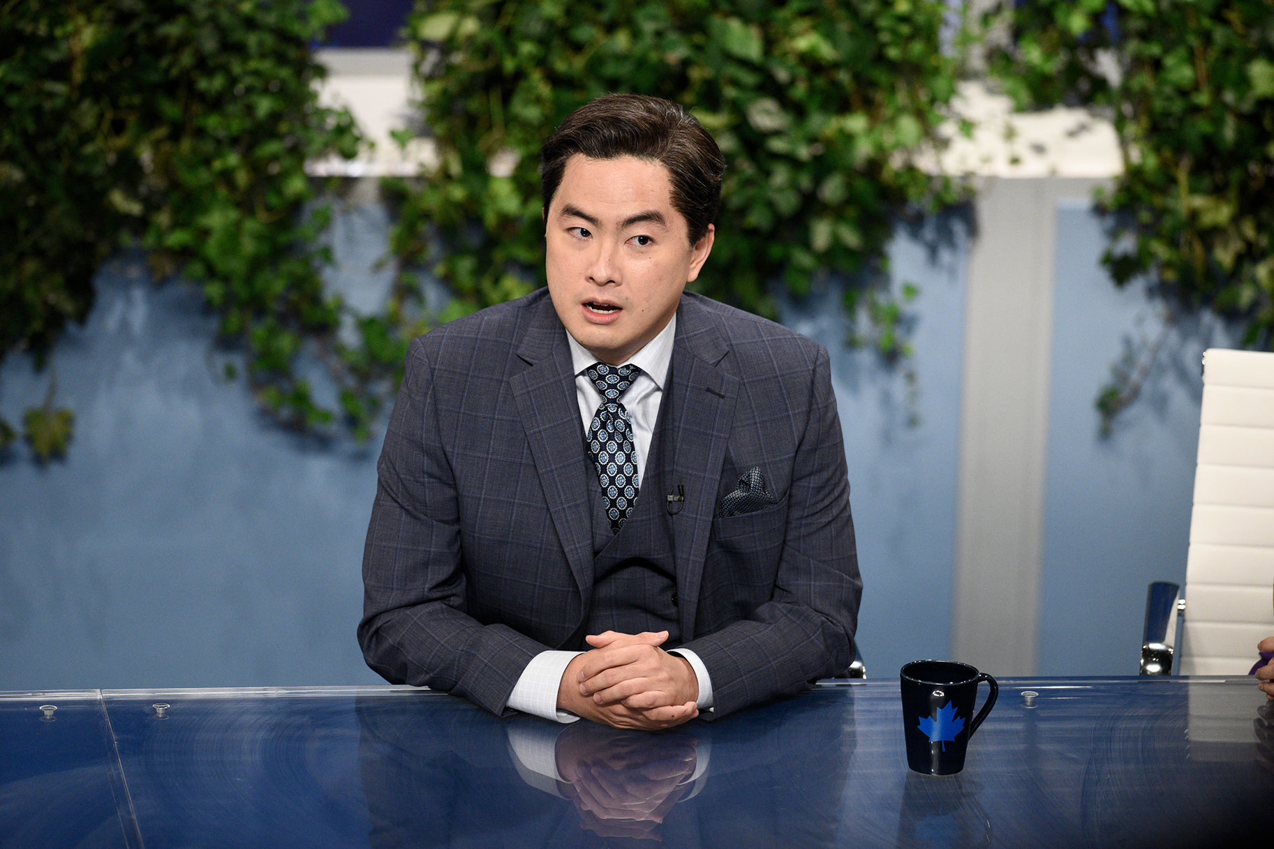 Bowen Yang playing a news reporter in an SNL skit
