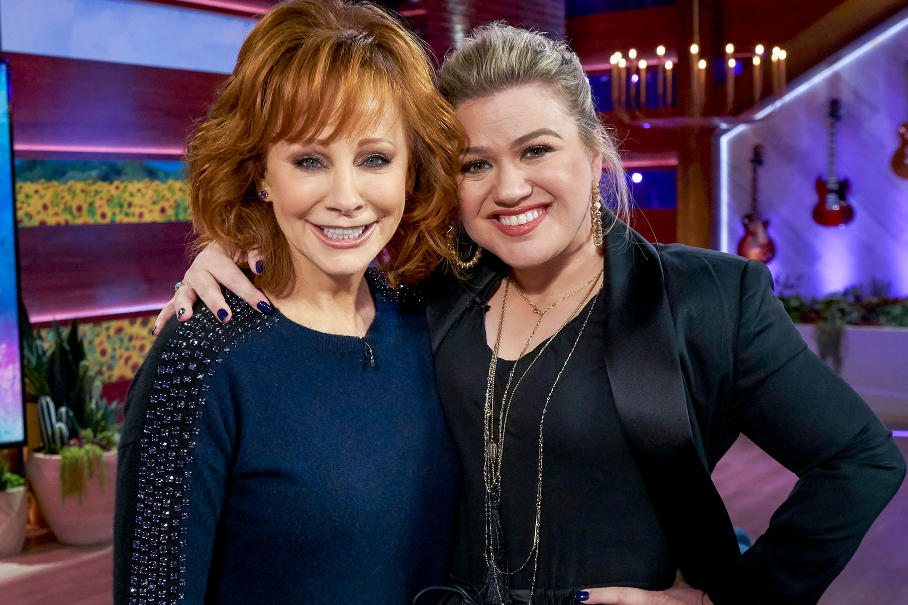 Kelly Clarkson and Reba hugging and smiling at the camera