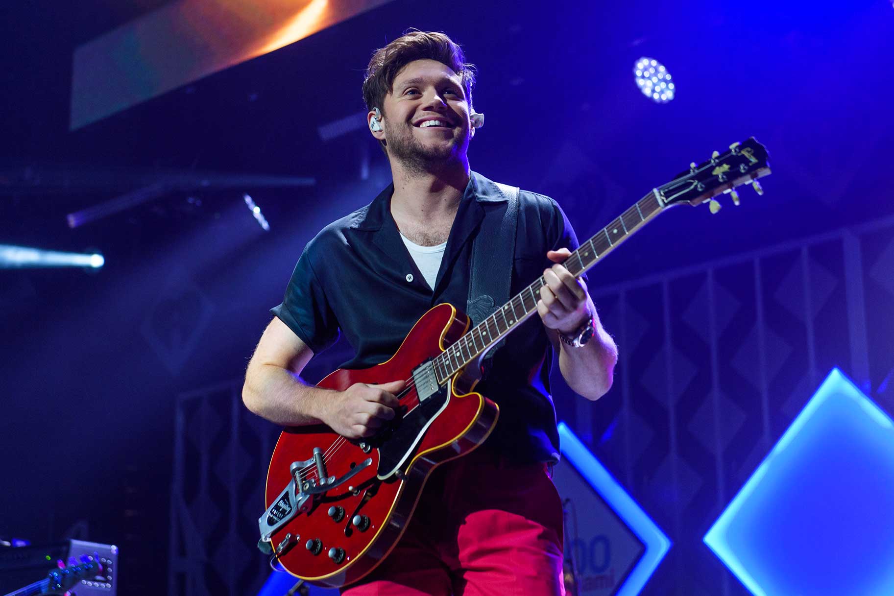 Niall Horan smiling and performing on stage at the Y100 2019 Jingle Ball.