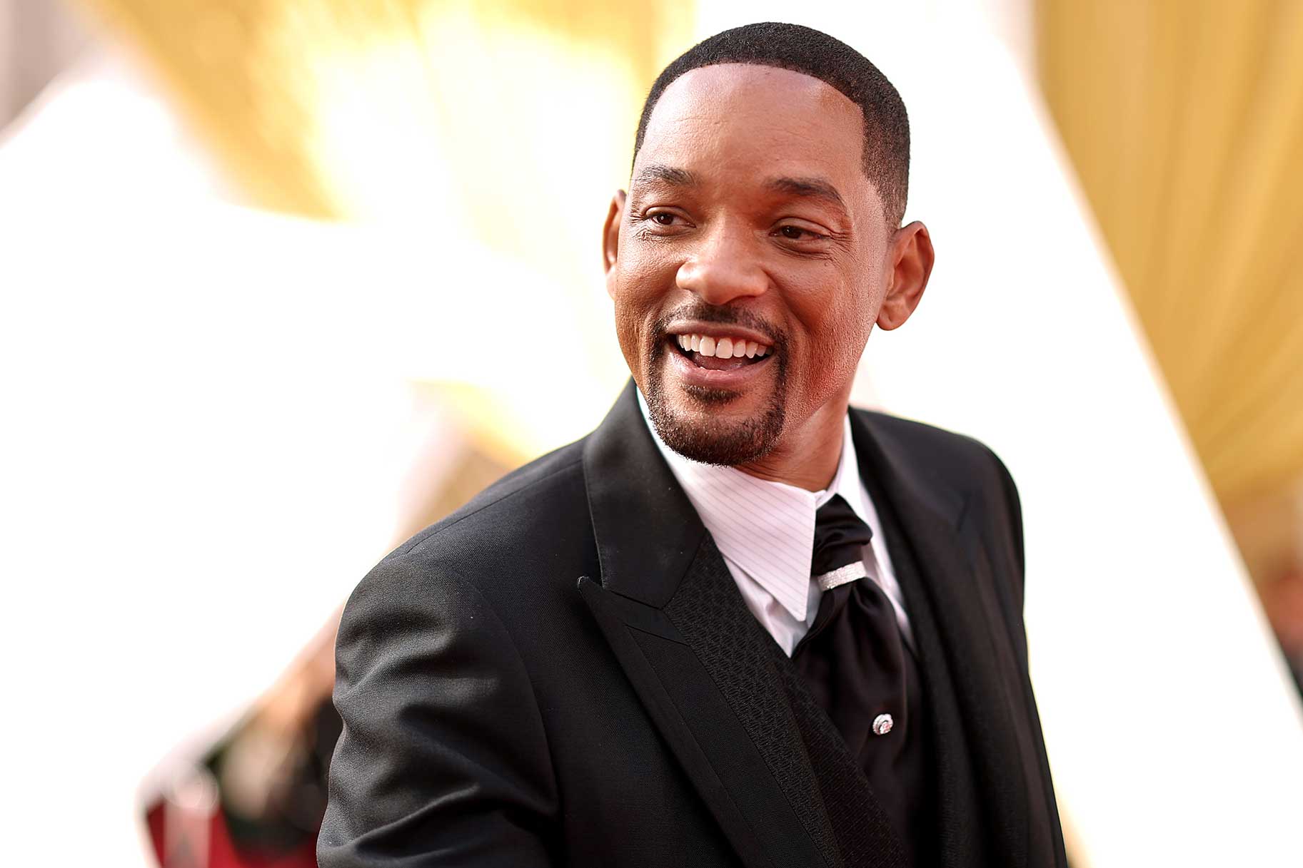Will Smith smiling on a red carpet