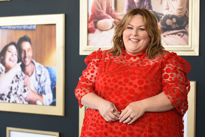 Chrissy Metz wearing a red dress and smiling at the camera