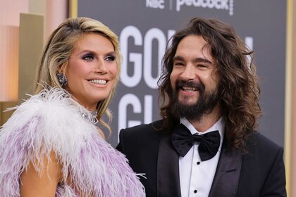 Heidi Klum And Tom Kaulitz smiling at the 80th Annual Golden Globe Awards red carpet.