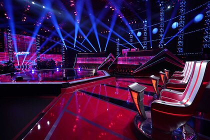 A photo showing the set of The Voice stage and judges' chairs