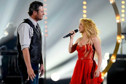 Blake Shelton and Shakira singing on stage.