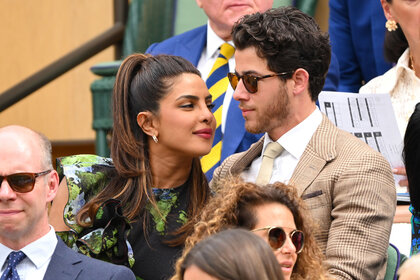 Priyanka Chopra and Nick Jonas whispering to each other while at a tennis match