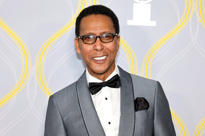 Ron Cephas Jones appears at an event in a grey suit.