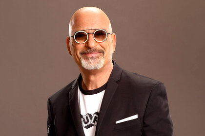 Howie Mandel in a black jacket white tee shirt and glasses for America's Got Talent