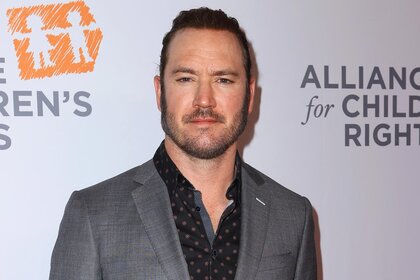 Mark Paul Gosselaar wears a greuy suit on the carpet for The Alliance For Childrens Rights