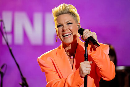 Pink performing on the today show wearing an orange blazer holding a microphone