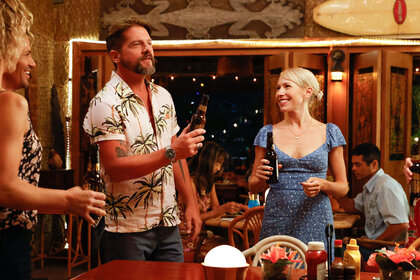 Rick (Zachary Knighton) and Suzy (Betsy Phillips) make a toast while surrounded by friends at a bar