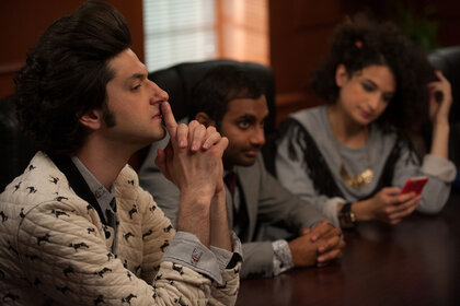 Ben Schwartz as Jean-Ralphio Saperstein, Aziz Ansari as Tom Haverford, and Jenny Slate as Mona-Lisa Saperstein seated at a table together