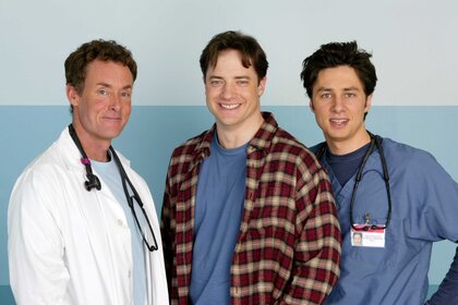 Dr. Perry Cox, Ben Sullivan, and Dr. John Dorian standing next to each other and smiling on the set of Scrubs.