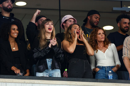 Taylor Swift and Blake Lively cheer from the stands during an NFL football game