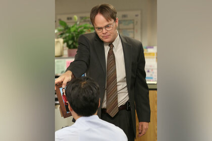 Dwight Schrute holds a picture frame up on The Office Episode 903