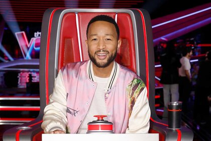 John Legend smiles in his coaches chair during The Voice Episode 2502