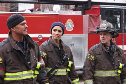 Kelly Severide , Stella Kidd, and Christopher Herrmann stand in uniform near a fire truck Season 12 Episode 8 "All the Dark".