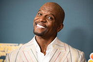Terry Crews smiles at the camera on the red carpet of an America's Got Talent event
