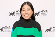 Awkwafina smiles on a red carpet at an event