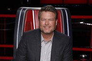 Blake Shelton smiles in a red chair on The Voice Episode 2217A.