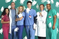The cast of Scrubs poses next to medical gloves in Season 1.