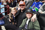 Michael Buble and his sons Elias and Noah sit in the stands and watch a hockey game