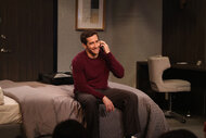 Reginald Kean (Jake Gyllenhaal) sits on a bed while talking on the phone in Saturday Night Live Episode 1864.
