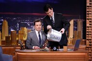 Stephen Colbert dumps change onto Jimmy Fallons desk on the tonight show episode 1