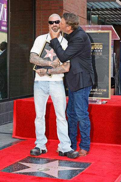 Blake Shelton kisses Adam Levine on the cheek during the Hollywood Walk of Fame Ceremony.