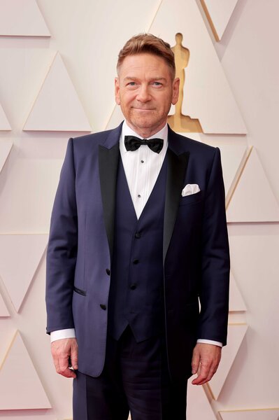 Kenneth Branagh attends the Academy Awards wearing a navy blue suit.
