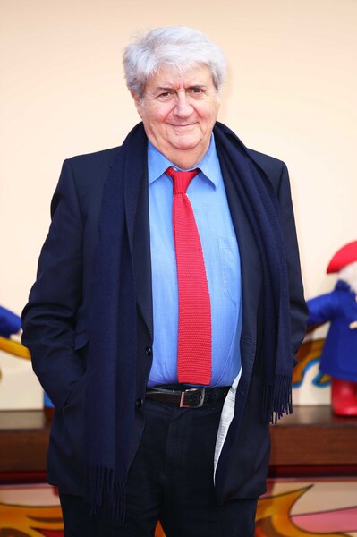 Tom Conti attends the Paddington 2 premiere wearing a navy suit with a red tie.