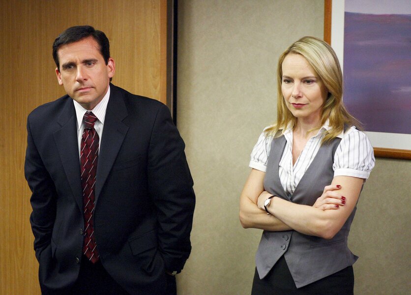 Michael and Holly standing side by side during a scene in The Office.
