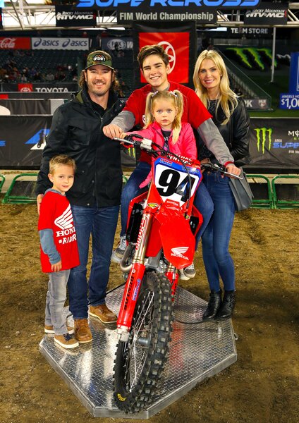 Mark Paul Gosselaar, Catriona McGinn and their children posing in front of a motocross in Angel Stadium.