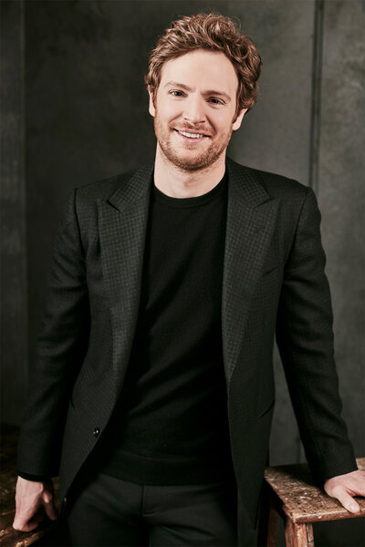 Nick Gehlfuss poses in an all black outfit for a photoshoot for chicago med