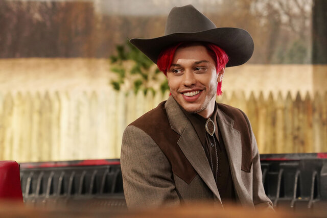 Pete Davidson wearing a red wig and cowboy hat in SNL's 'Squid Game' Sketch