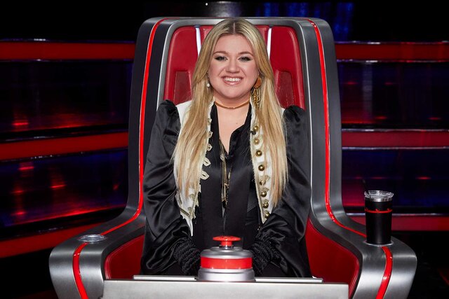 Kelly Clarkson smiling in her chair.