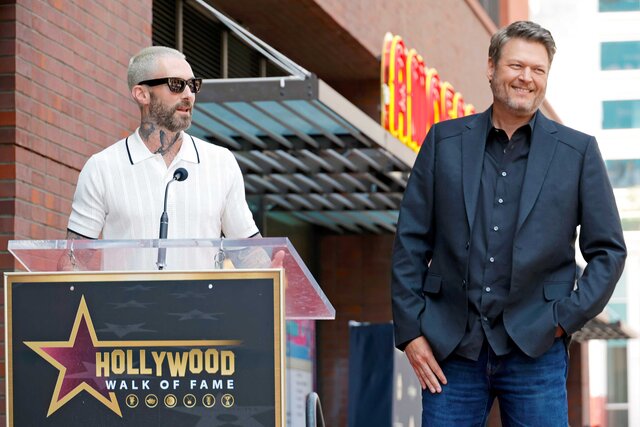 Adam Levine and Blake Shelton speaking on stage at Blake Shelton's The Hollywood Walk Of Fame Ceremony.