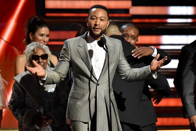 John Legend accepting an award on stage at the 62nd Annual Grammy Awards.