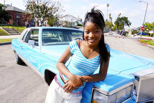 Keke Palmer posing in front of a blue car for a music video in 2006.