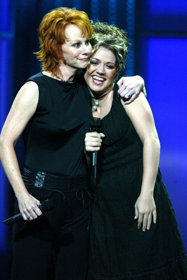 Reba McEntire and Kelly Clarkson hugging on stage back in 2006.