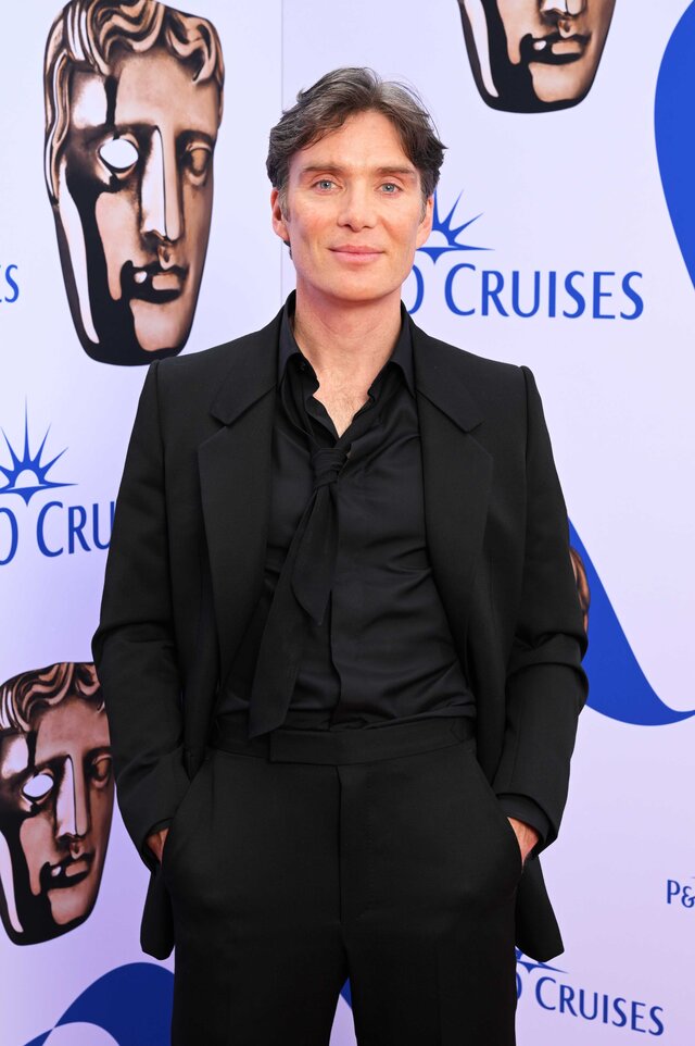 Cillian Murphy posing on the red carpet wearing a black suit.