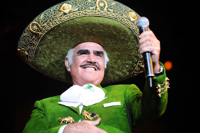 Singer Vicente Fernandez holds the mic out while singing