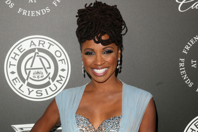 Shanola Hampton smiles on the red carpet while wearing a light blue dress