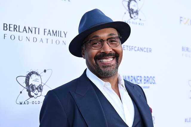 Jesse L Martin smiles for photos on a red carpet