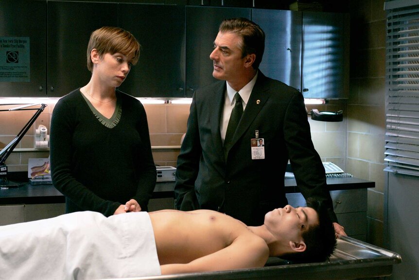 Julianne Nicholson and Chris Noth standing over a body on an episode of Law & Order: Criminal Intent.